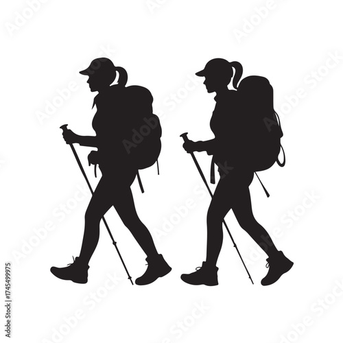 Two women hikers with backpacks and trekking poles silhouette