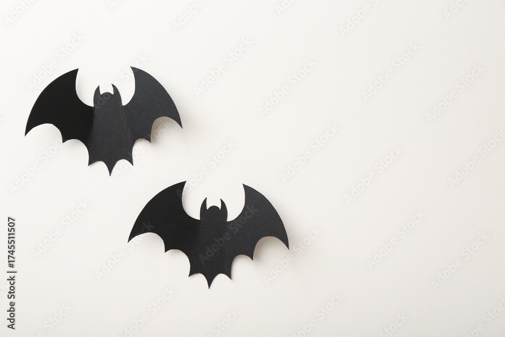 Naklejka premium Halloween decor. Black paper bats on white background, flat lay. Space for text
