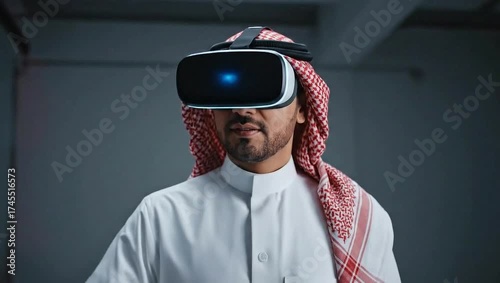 A person in traditional attire wears virtual reality goggles, illuminated by a blue glow