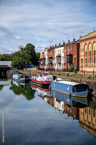 Fototapeta Canal boats and old buildings in a harbor