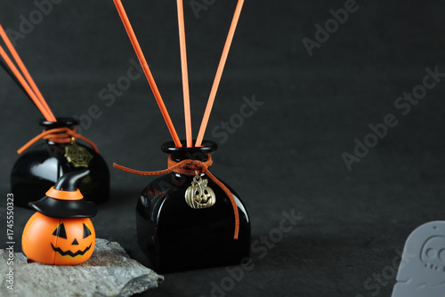black luxury aroma scent reed diffuser glass bottle on black table to create mystery and luxury ambient bedroom with black cracked cement wall background at night on Halloween day party air freshener