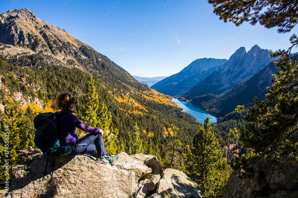 Fototapeta premium Young hiker woman in autumn in Aiguestortes and Sant Maurici National Park, Spain