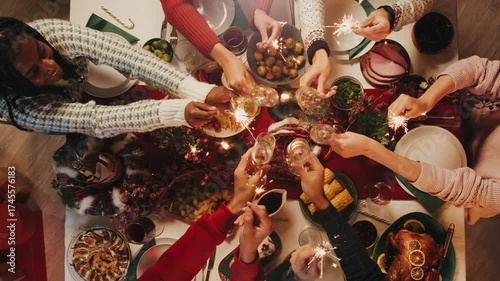 Hand lighting candles on dining table top view. Friends celebrating new year, delicious dishes, cooked homemade food on plates. Christmas party at home. 