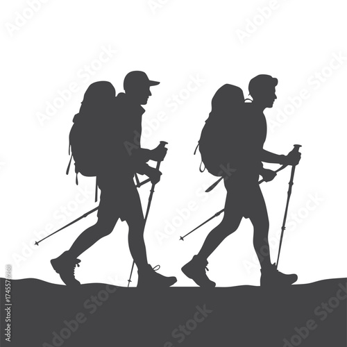 Two hikers with backpacks and trekking poles walking in silhouette