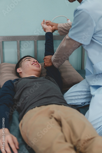 A mentally healthy young man with disability being examined by doctor or physical therapist's for muscle stiffness and dyskinesia are common symptoms in people with CP(cerebral palsy).