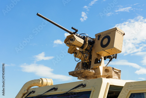 Heavy machine gun. Weapon on the top. Armament and weaponry in military army. Blue sky with clouds as copy space.
