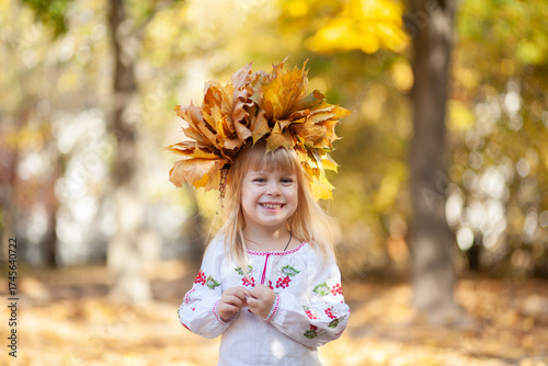 Bright Autumn Day With a Joyful Girl Wearing a Crown of Colorful Leaves, Celebrating the Spirit of Halloween in a Picturesque Outdoor Setting