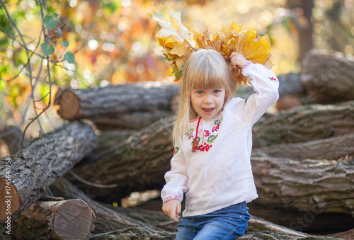 Young Girl Enjoys the Beauty of Autumn by Playing With Colorful Leaves in a Forest While Celebrating Halloween in October