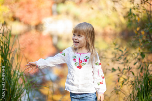 Joyful Girl Enjoying a Beautiful Autumn Day by the Water, Celebrating the Magic of Halloween During the Colorful Days of October