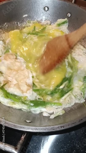 Stirring Eggs and Spring Onions in a Hot Pan
