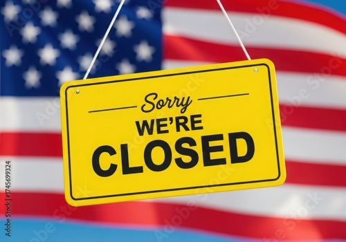 Yellow sorry were closed sign hanging in front of us flag