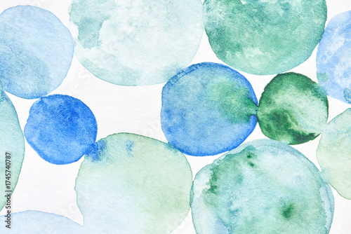 Abstract watercolor circles in blue and green with a soft textured background on white canvas.