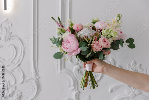 Fotografie Hand holding a bold, modern bridal bouquet with pink peonies, blush roses, King