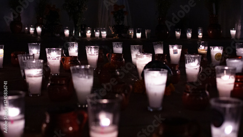 Fotografi Gran conjunto de veladoras tradicionales encendidas en vasos de vidrio y jarrito