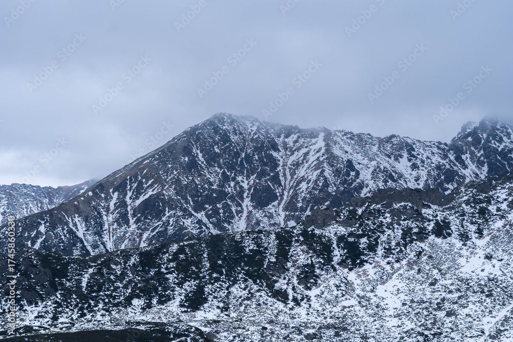 Obraz premium Snow-Capped Mountain Peaks Hidden in Misty Fog