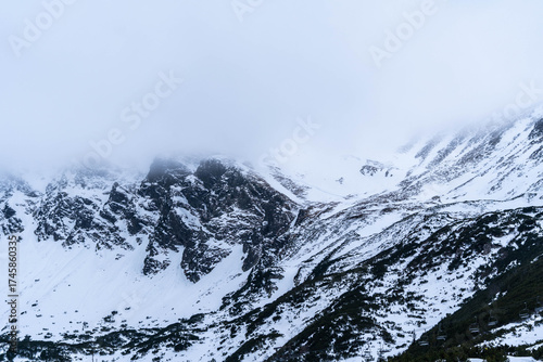 Snow-Capped Mountain Peaks Hidden in Misty Fog