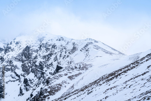 Snow-Capped Mountain Peaks Hidden in Misty Fog
