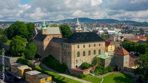 Cinematic aerial orbit around Akershus Castle and Fortress in Oslo, Norway. Historic medieval architecture captured in smooth drone motion under bright summer skies. Iconic heritage landmark footage