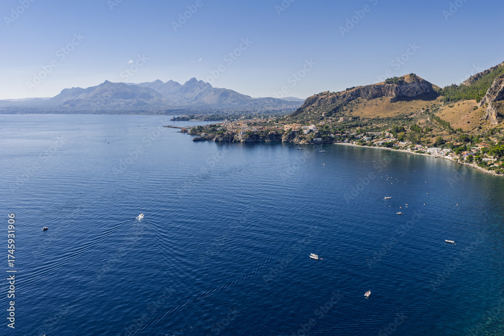 Obraz premium Capo Zafferano Italian coastal promontory and lighthouse aerial drone view by the Tyrrhenian Sea in Bagheria, Sicily Italy with rugged cliffs lush Mediterranean flora crystal clear water