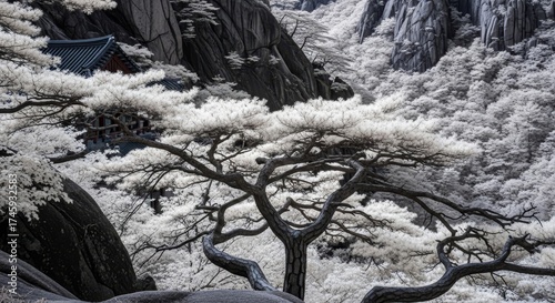 Dramatic infrared landscape with twisted bare tree branches against rocky granite cliffs and traditional Korean temple architecture in mountainous terrain