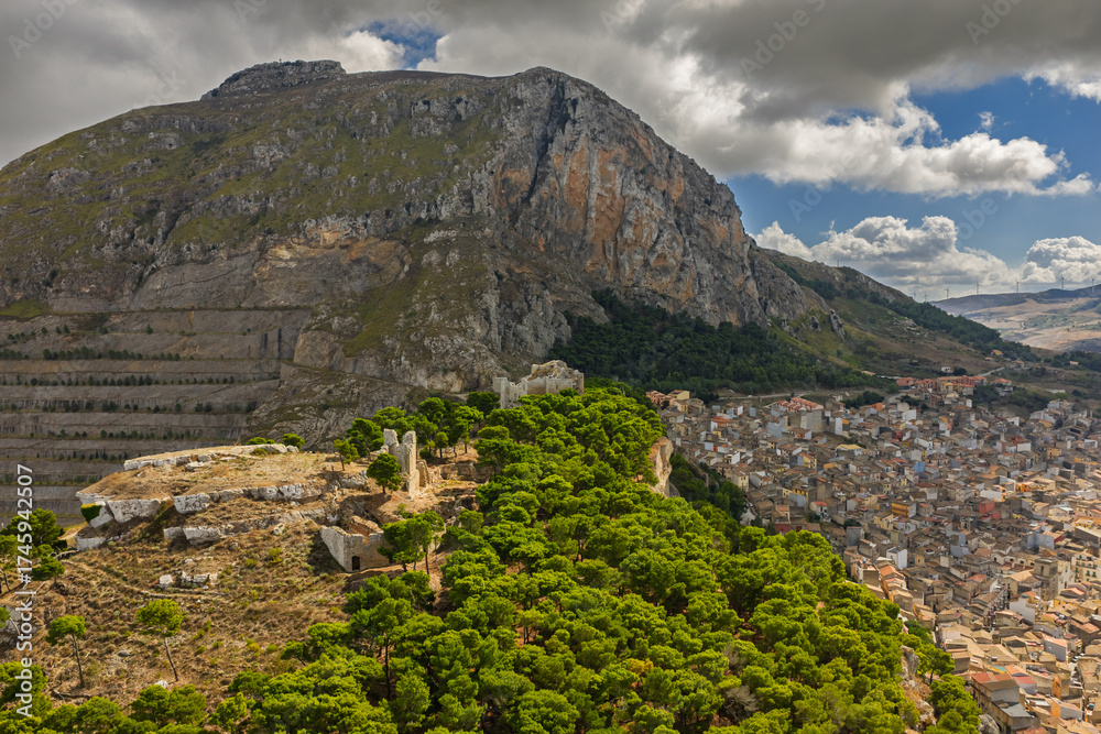 Fototapeta premium Aerial drone view of Caltavuturo, a historic Sicilian mountain town in Palermo, Italy, featuring its medieval castle, rugged surrounding cliffs, and scenic landscapes of the Madonie Mountains