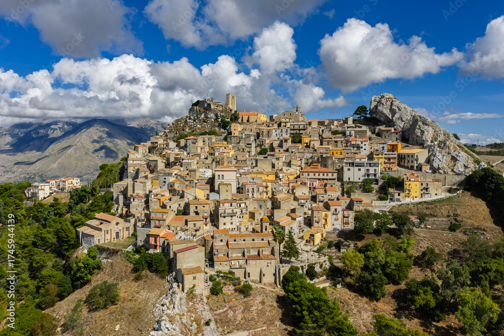 Fototapeta premium Aerial drone view of Sclafani Bagni, a small historic Sicilian mountain town perched on cliffs with panoramic views of Caltavuturo and rugged Madonie Mountains, Sicily, Italy.Small Village in Sicily
