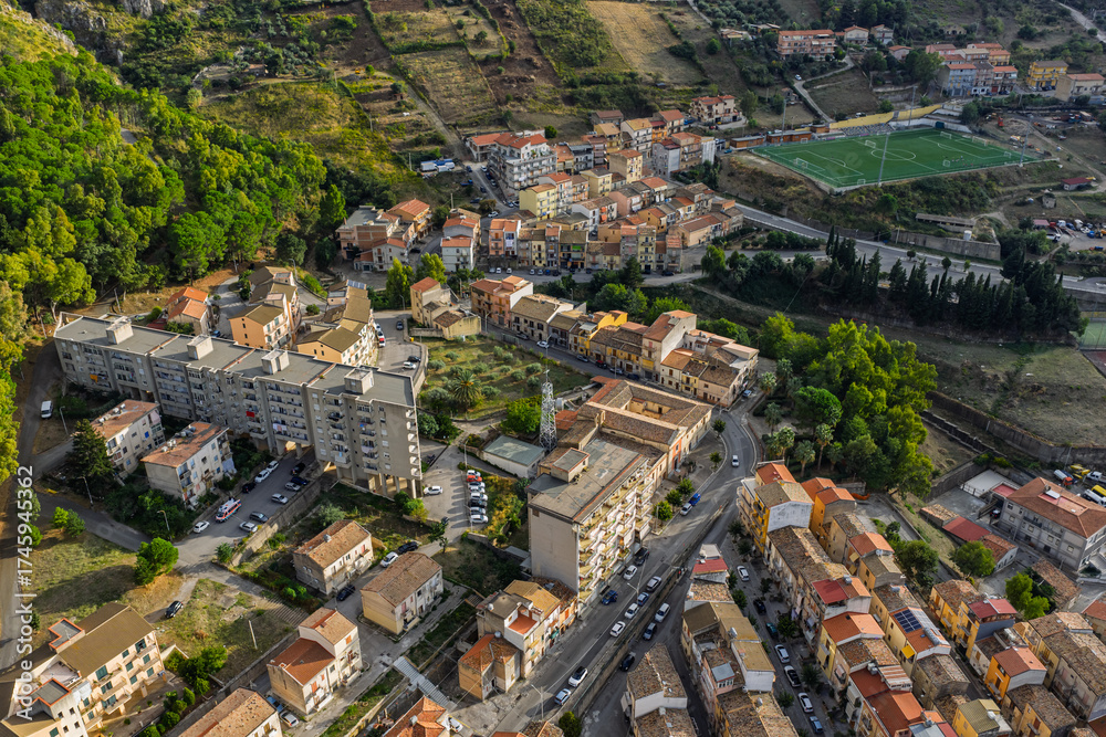 Obraz premium Aerial drone view of Collesano Sicilian mountain town at sunset with Basilica San Pietro church and historic stone streets in the Madonie Mountains, Sicily, Italy. Old mountain town in Sicily