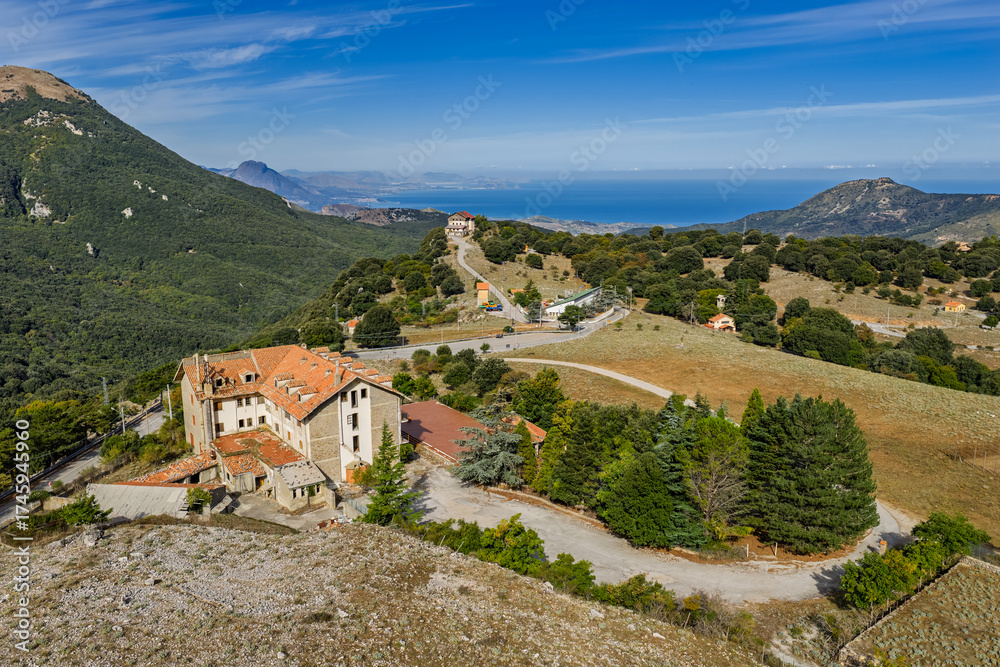 Fototapeta premium Aerial drone view of Piano Zucchi, a historic Sicilian mountain village at 1100 meters above sea level, surrounded by dense oak forests in the heart of Madonie Park, Isnello, Sicily, Italy
