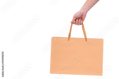 Hand holding a blank brown paper bag, isolated on a transparent background.