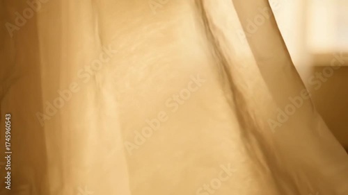 Soft, flowing sheer curtains gently sway in a sunlit room, creating a serene and airy atmosphere.