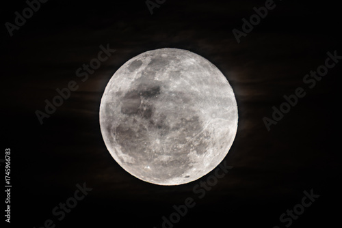 The Harvest Moon supermoon rises in the cloud covered sky