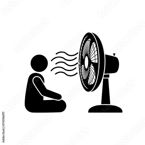 Person sitting in front of a fan, enjoying the cool breeze