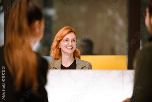Canvastavla Friendly receptionist greets clients with a warm smile at a modern office during