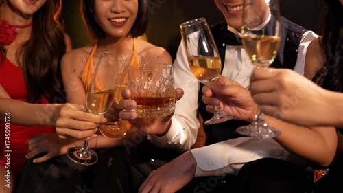  Beautiful woman having fun with group of friends clinking champagne glasses during celebration party. Drink concept.