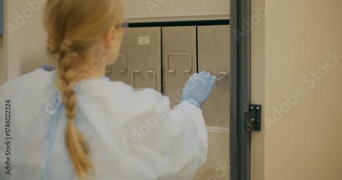 Female Scientist Opening Laboratory Freezer for Research