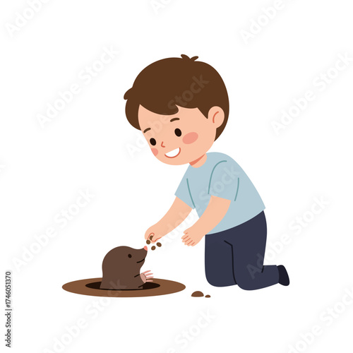 A child joyfully feeding a mole from a hole in the ground.