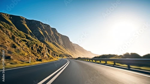 The simple pleasure of a road trip on a scenic coastal highway winding through mountains under a bright sun