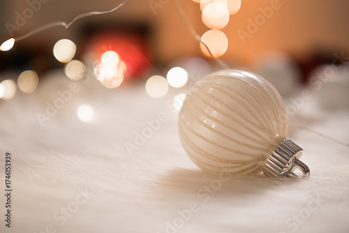 Beautiful white christmas ball on wool with bokeh lights background.
