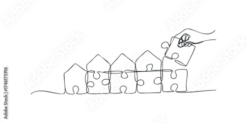 Hand placing last piece on jigsaw house row