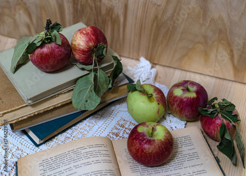 Ripe apples on a stack of books. Autumn background with apples.