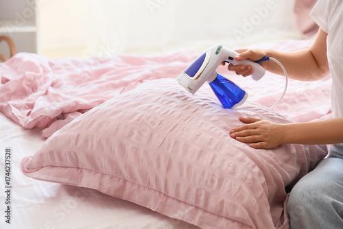 Woman steaming pink pillow ...
