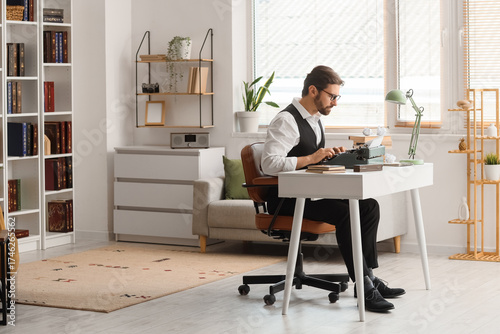 Focused male author typing ...