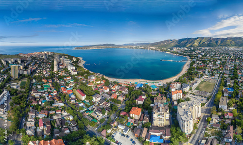 Seaside resort of Gelendzhik. Aerial panorama. Round Gelendzhik Bay with blue water. Beach around bay. Caucasus Mountains in background.