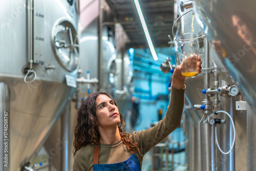 Obraz na płótnie Woman brewer controlling beer quality in factory
