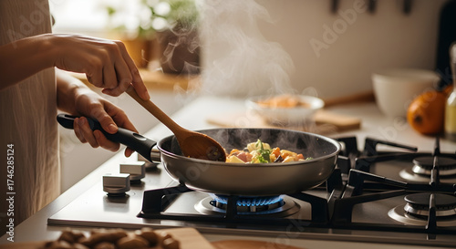 kitchen person stirring fresh vegetables in a steaming frying pan on a gas stove in a modern kitchen capturing the warmth and activity of home cooking a healthy meal