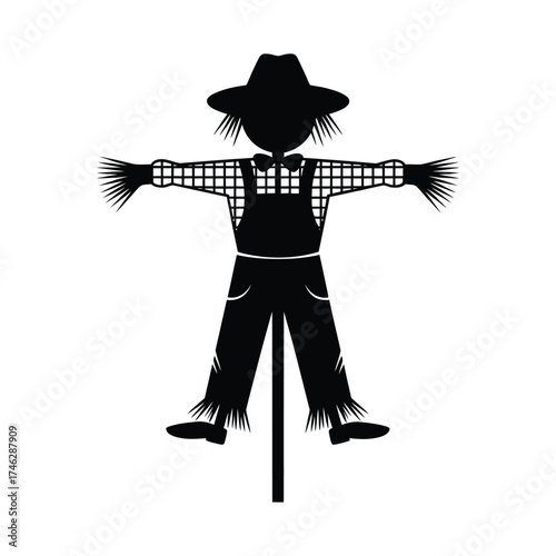 Silhouette of a scarecrow wearing a hat and overalls on a pole