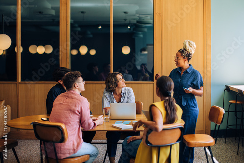 Diverse group of colleagues discussing ideas around a small conference table