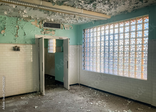 Open door in a decrepit room with peeling paint inside an abandoned and haunted hospital 
