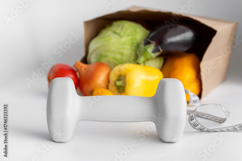 healthy eating, diet, and fitness concept - vegetables and dumbbells
