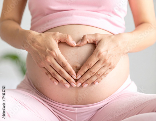 Wallpaper Mural manos femeninas formando un corazón sobre el vientre de una mujer embarazada con ropa de yoga, símbolo de amor maternal, esperanza y vida en el embarazo Torontodigital.ca